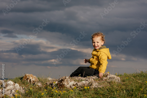 Wallpaper Mural Cute toddler in a yellow jacket enjoying and playing in the mountains at sunset. Little explorer learning through play.  Torontodigital.ca