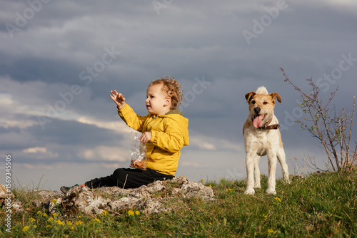 Wallpaper Mural Cute toddler in a yellow jacket enjoying and playing in the mountains at sunset. Little explorer learning through play.  Torontodigital.ca