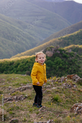 Wallpaper Mural Cute toddler in a yellow jacket enjoying and playing in the mountains at sunset. Little explorer learning through play.  Torontodigital.ca