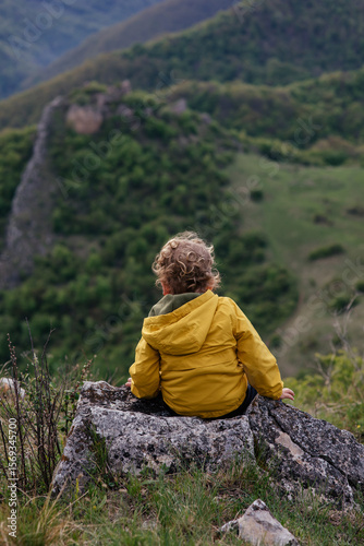 Wallpaper Mural Cute toddler in a yellow jacket enjoying and playing in the mountains at sunset. Little explorer learning through play.  Torontodigital.ca