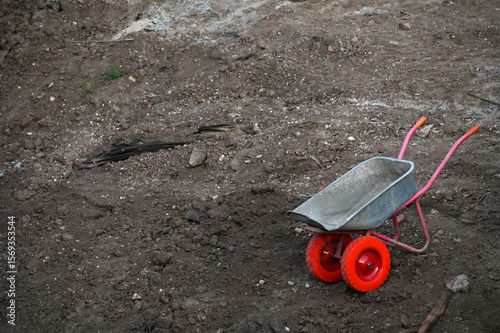 Empty wheelbarrow on the background of construction debris with copy space