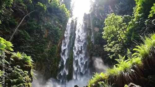 Majestic Waterfall Flowing Through Lush Green Nature Landscape in Serene Forest Environment and Scenic View