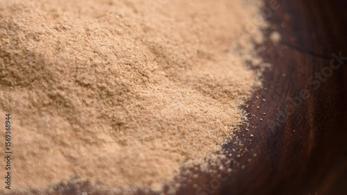 Ayurvedic Ashwagandha root powder in wooden bowl. Calming anti-stress supplement. Rotation