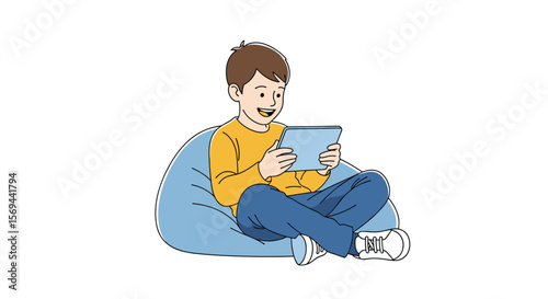 Young boy happily playing on a tablet while sitting on a beanbag chair indoors
