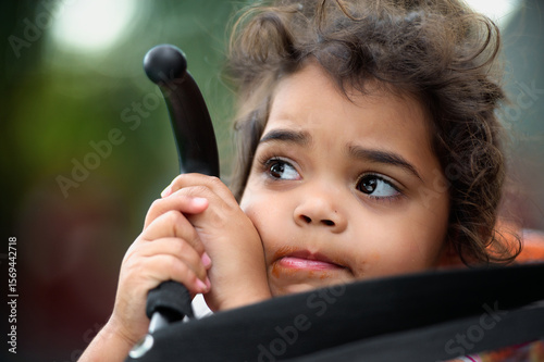Three Year Old Aboriginal Girl with Two Hands Holding Pusher