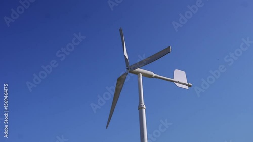 Wind Turbine Generating Renewable Energy Under Clear Blue Sky, Showcasing Clean Technology and Commitment to Environmental