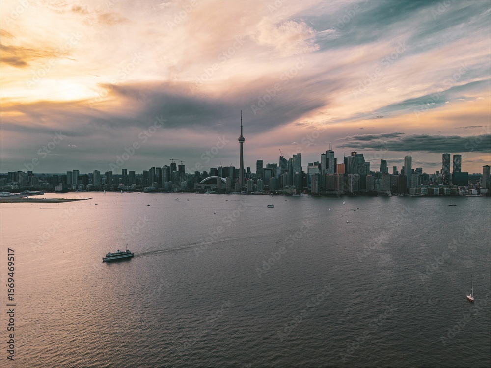 Naklejka premium Toronto skyline at sunset with a ferry on Lake Ontario.