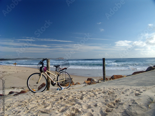 Bicycle parked at a post by the beach