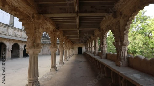 Ancient Architectural Stone Corridor with Arched Pillars and Natural Surroundings