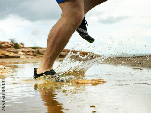 Running through a puddle and splashing at the beach