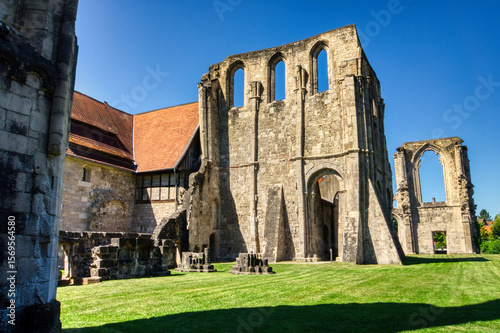 Medieval ruins of the Cistercian Walkenried Monastery in Lower Saxony, Germany. Gothic arches, stone walls, and green lawns under a clear blue sky reflect centuries of religious history