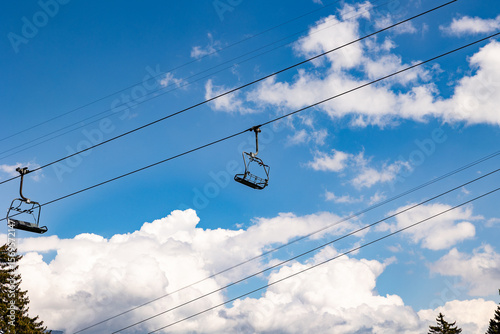 Empty and unoccupied ski lift, Swiss Alps. Switzerland, Canton St. Gallen. Clear sky with clouds, summer. Hiking, traveling, tourism, destination, recreation, leisure activity.