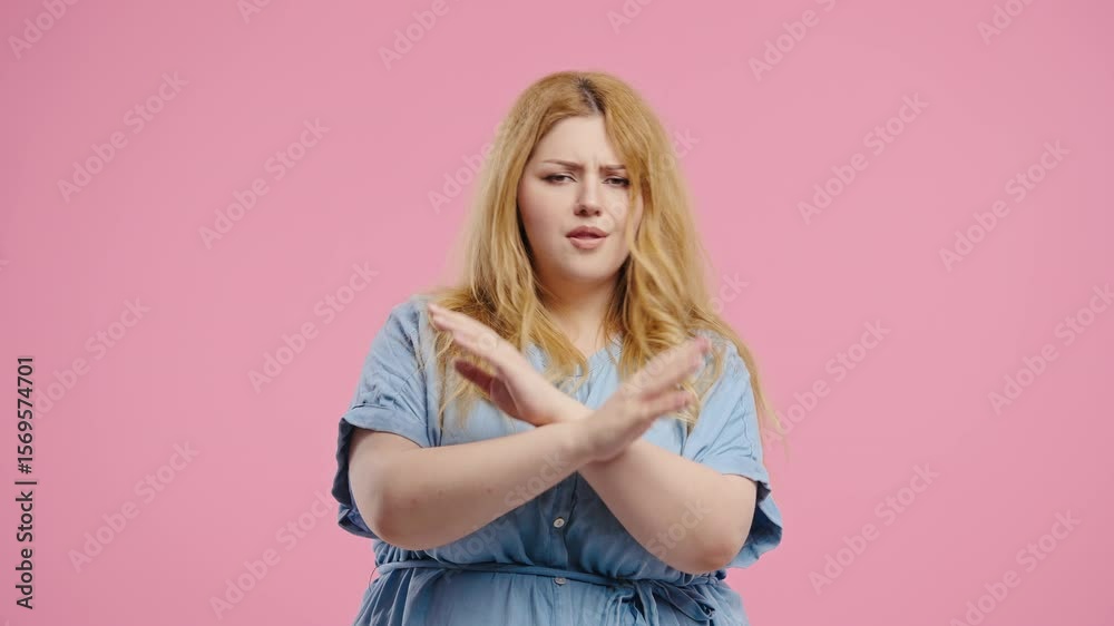 Curvy woman crosses arms in front of chest to express refusal strong disapproval