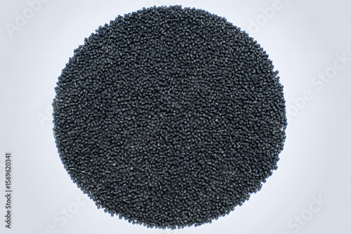 Circular Pile of Black Plastic Granules on White Background: Essential Raw Material for Industrial Production and Manufacturing