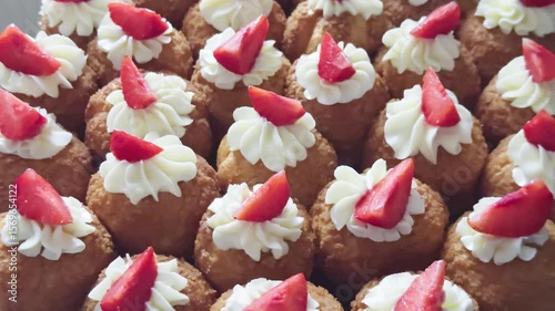 Sweet pastries with strawberry and cream, neatly arranged on a tray for serving