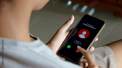 Person Blocking Suspected Spam Call on Smartphone