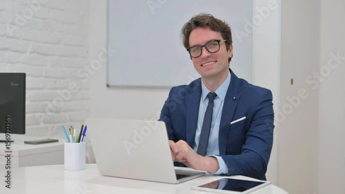 Mature Adult Businessman Smiling at Camera at Workspace
