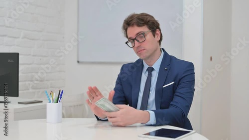 Businessman Counting Money at His Desk