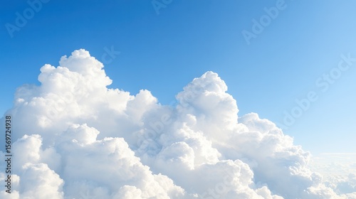 A serene view of fluffy white clouds against a clear blue sky, evoking peace and tranquility in the atmosphere.
