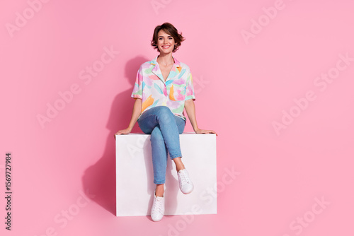 Full body portrait of nice young woman sit podium empty space wear shirt isolated on pink color background