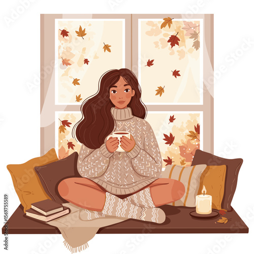 Young woman sitting on window seat with a cup in cozy autumn room  