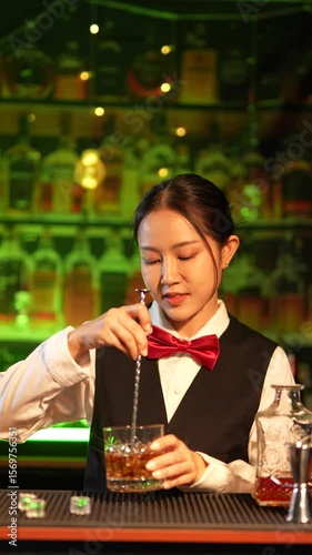 Professional female bartender preparing alcoholic drinks in a bar