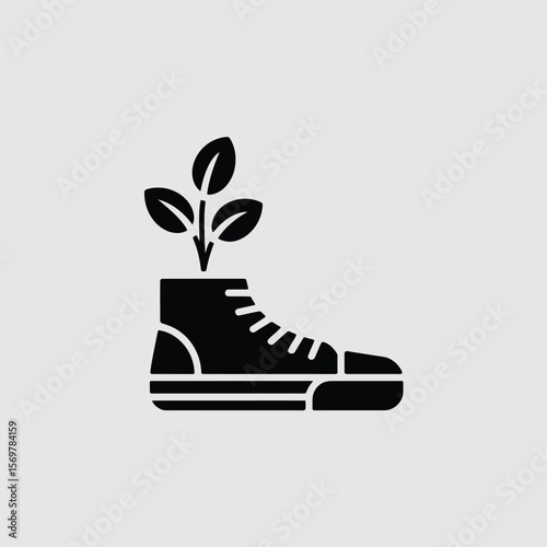 Black silhouette of a sneaker with a green plant growing out of it