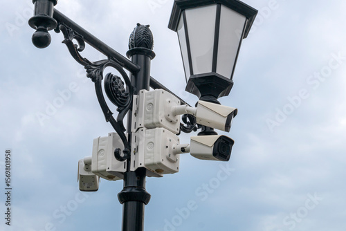 CCTV camera on a lamp post against a blue sky
