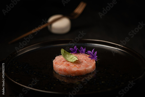 Raw shrimps tartare on a black plate
