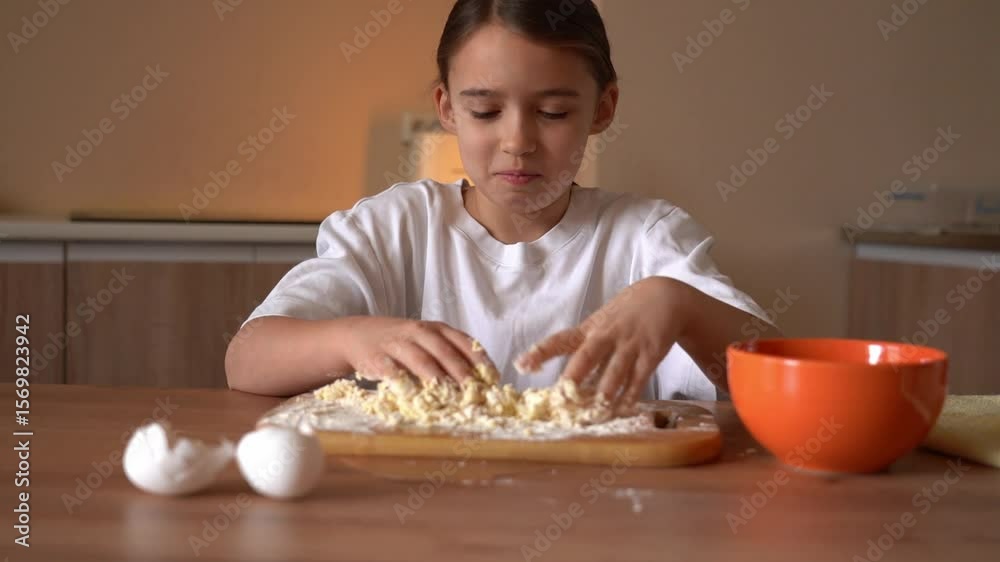 Child enjoys making dough in a cozy kitchen while learning baking skills with simple ingredients Child enjoys making dough in a cozy kitchen while learning baking skills with simple ingredients