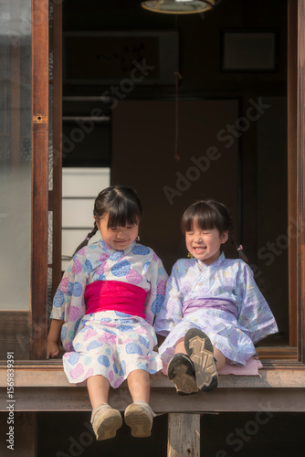 縁側で笑顔を見せる浴衣姿の姉妹