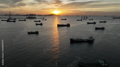 Aerial view oil tanker ship and gas tanker ship at sunset, Silhouette oil and gas tanker ship at oil and gas terminal, Global business import export logistic transportation oil and gas petroleum.