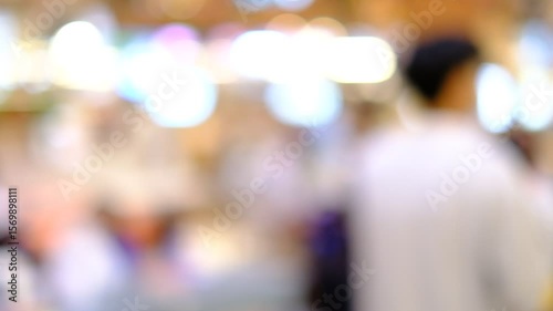 A blurry image of people in a restaurant with a blurry background. Scene is somewhat chaotic and disorganized, as the people are scattered throughout the scene and the background is blurry
