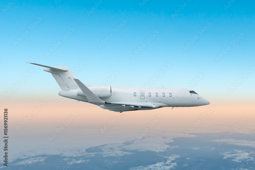 Obraz premium White luxury bizjet flying in the air above the clouds
