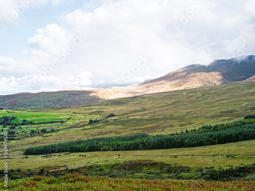 Carrauntoohil walkway offers stunning views of mountains and valleys in county kerry, ireland on a partly cloudy day.