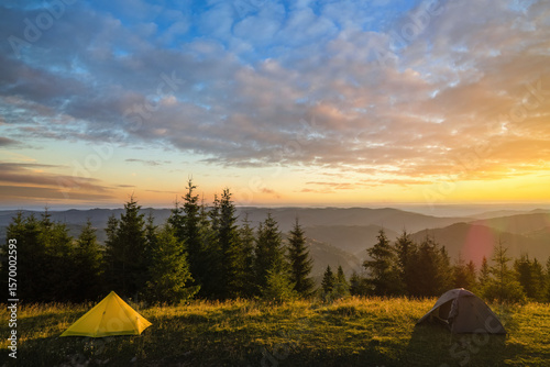 Tourist camping tent on mountain campsite at bright sunny evening. Active tourism and hiking concept