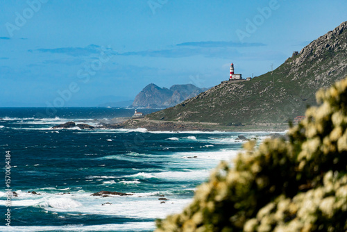 Scenic coastal view along the Portuguese Camino near Cape Silleiro lighthouse in Galicia Spain, with dramatic cliffs, ocean waves, and a picturesque trail on the western edge of Europe