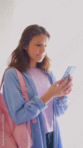 Worried young woman awaiting academic news on phone with visible tension. Suitable for exam periods, admissions and dramatic narratives