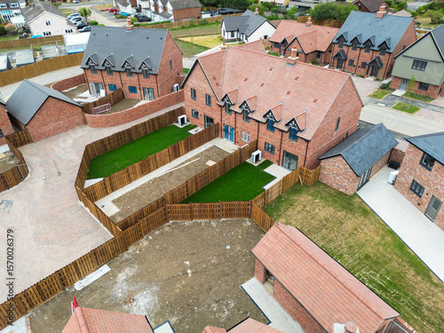 фотографія Aerial view of newly completed terraced houses showing installed heat pumps and lush green lawns