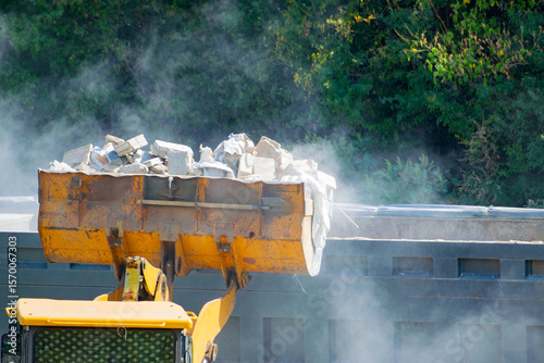 Removing construction waste with a bulldozer. loading into a dump truck