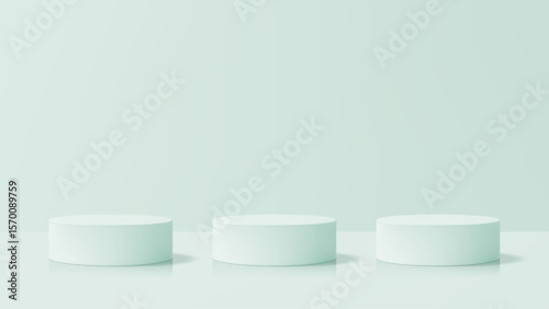 Three light green cylindrical product podiums in a simple studio. Empty stage for product presentation, cosmetic display, or showcase.