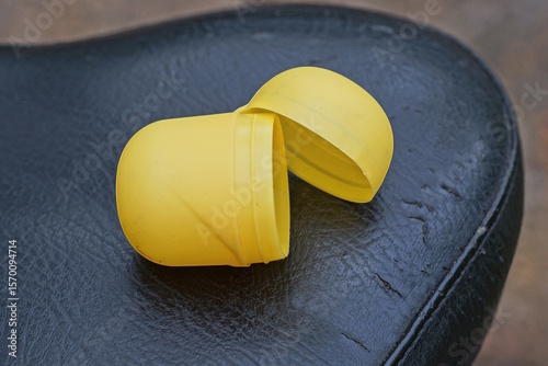 Fototapeta Naklejka Na Ścianę i Meble -  one small open oval yellow plastic box lies on a black table on a summer street