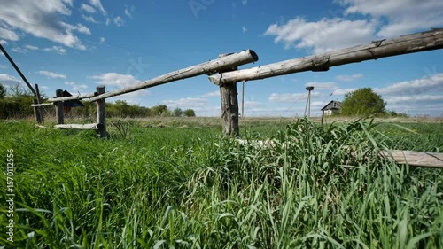 Old wooden fence and small bridge leading to abandoned slavic village house