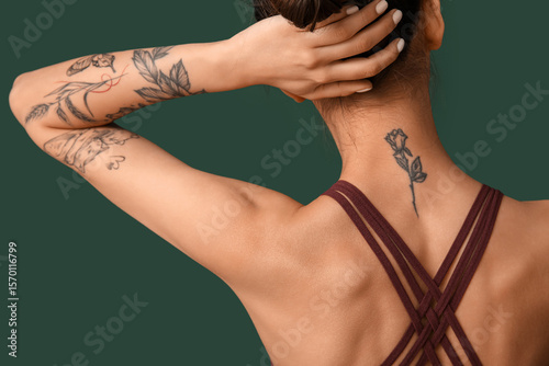 Tattooed young woman on gre...