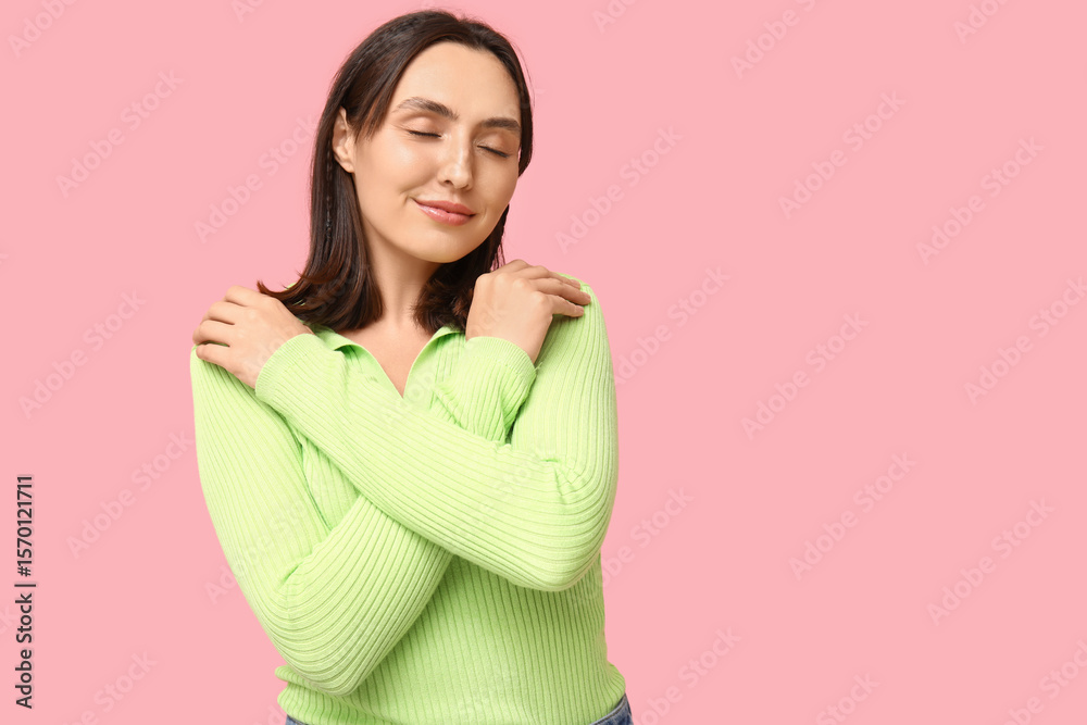 Obraz premium Young woman hugging herself on pink background