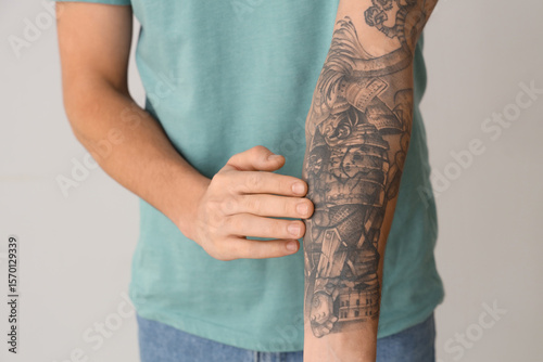 Young man with tattooed arm...