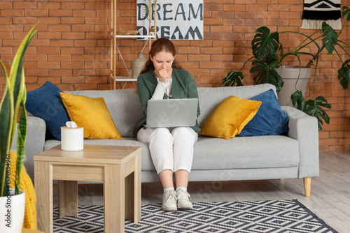 Sick young woman with lapto...