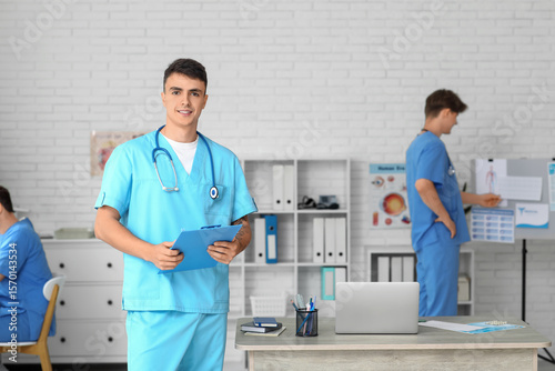 Male doctor with clipboard ...