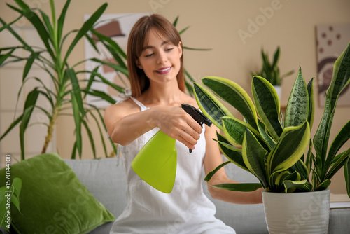 Young female gardener spray...