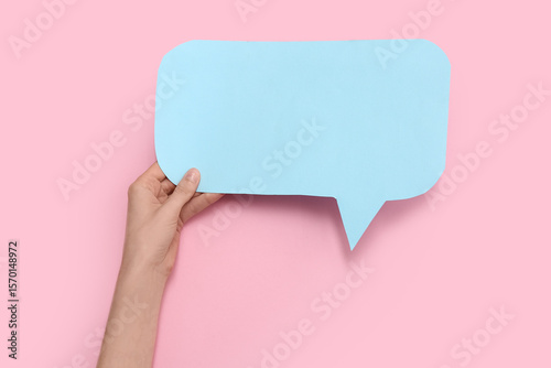 Fototapeta Naklejka Na Ścianę i Meble -  Female hand with blank paper speech bubble on color background, closeup